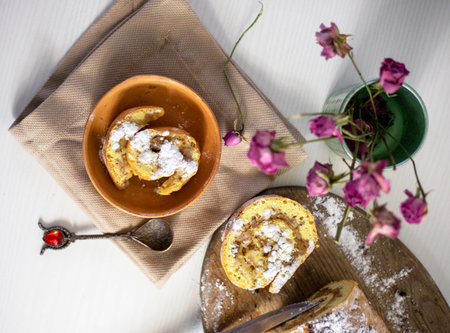 freshly baked two piece of apple roll on a napkin with crumbs and a rose, family breakfast,...