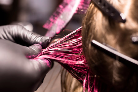 close-up professional coloring strands of blond hair in bright pink color, beauty salonの写真素材