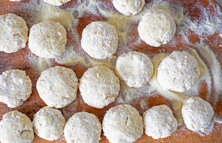 sweet cheesecakes on a wooden board in flour before frying