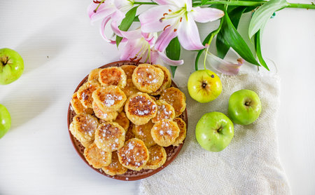 good morning, breakfast with cheese cakes, green apples and pink lilies on a white table lit by the sun, top view, horizontal,の写真素材