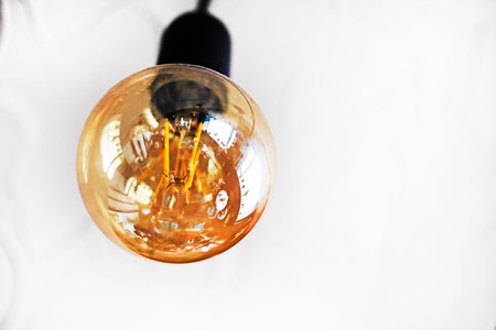 Close -up light bulb on a light wall operating from electricity, electricity,