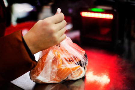 scan slices of salmon steak in a transparent bag at a self-service checkout. Purchaseの写真素材