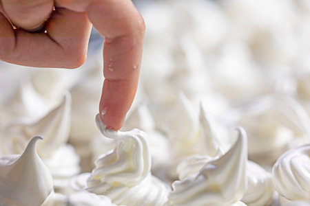 child's index finger tastes the meringue that has not yet been placed in the oven.の写真素材