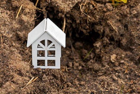 white house on the background of cracked earth. Ecological disaster earthquake, earth dayの写真素材