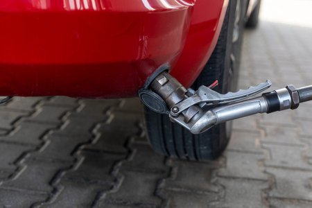 fill the gas filling nozzle of the member side of the car on gas at the gas station during the day....
