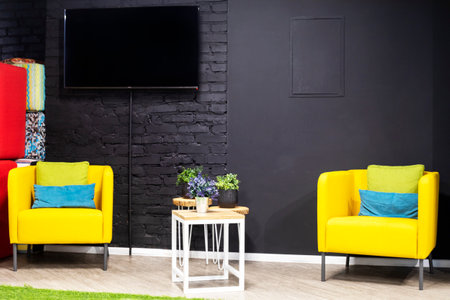 two soft stylish yellow armchairs near a gray brick wall in the office. interior layoutの写真素材