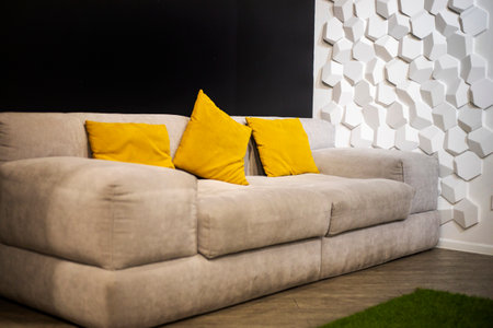 soft light fabric sofa with yellow pillows in a modern interior. A place to relax in the officeの写真素材