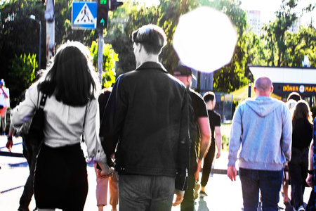 couple in love holding hands on the street in the glare of the sun among the crowd Authenticity
