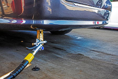 black stopper or cap from the filling device LPG at the gas station near the car being filled with gas.の写真素材