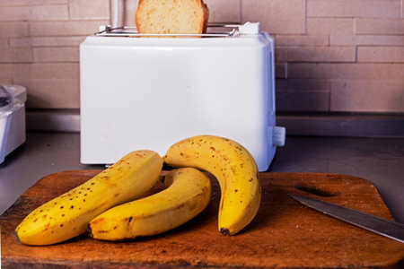 bunch of ripe bananas in the kitchen near the toaster. breakfastの写真素材