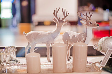 decorative deer near Christmas candles in the interiorの写真素材