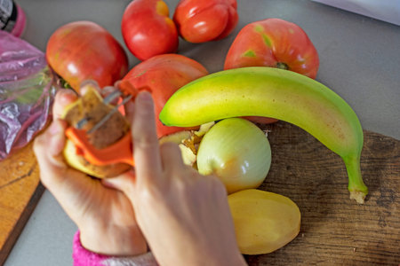 green banana next to tomatoes on the countertop in the kitchen