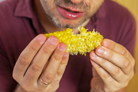 man finishes a pumpkin of sweet corn with both hands
