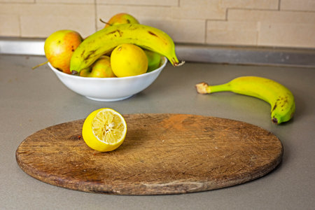 plate with apples, bananas and lemons in the kitchenの写真素材