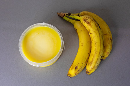 bunch of bananas next to an open jar of banana oil. flatlayの写真素材