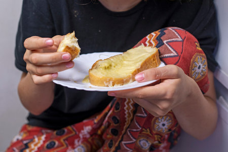 happy teenage girl bites a sandwich with hot cheeseの写真素材