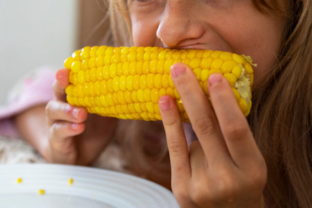 holding a hot yellow appetizing head of sweet corn in your hands before eating it