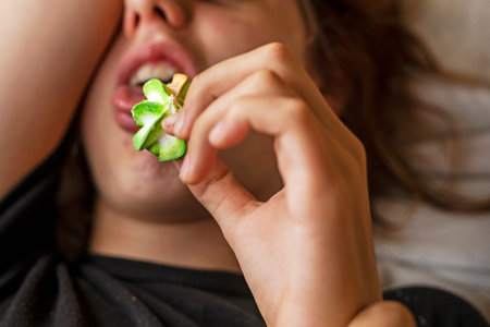 teenage girl lying down eating multi-colored marmeshow