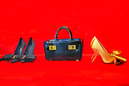 stylish black women's bag with black and gold women's shoes on a red background in a supermarket. Fashion & Styleの写真素材