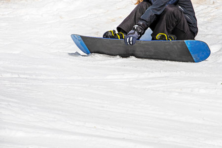 snowboarder sits on a snowboard on wet, loose snow before skiing. active recreationの写真素材