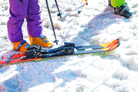 skier puts on his ski boots on a snowy slope on a sunny day. Active family vacationの写真素材