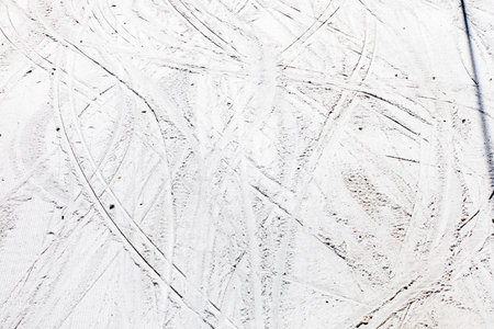 snowy slope with imprints from lying in the early morning, top view