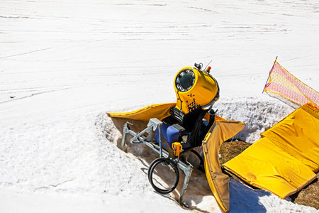 snow generator on a snow slope at a resort on a sunny day. Active recreation
