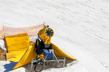 snow generator on a snow slope at a resort on a sunny day. Active recreation