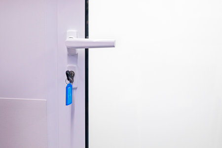 metal handle on a white closed door with a key installed. Modern interiorの写真素材