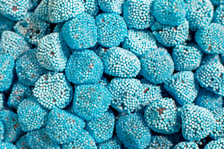 background of blue jelly sweets in the shape of raspberriesの写真素材