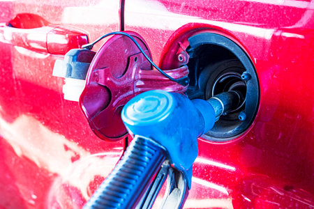 red car at a gas station is filling up with gasoline. Economic crisis. rising prices for oil and fuelの写真素材