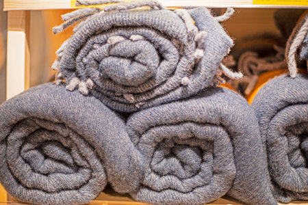 close-up woolen gray blankets rolled up on a counter in a supermarket. de-season