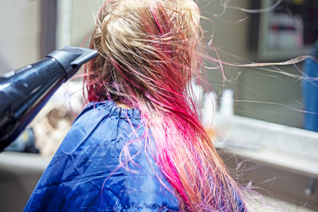 stylist blow-dries wet bright pink and purple hair. stylish hairstylesの写真素材