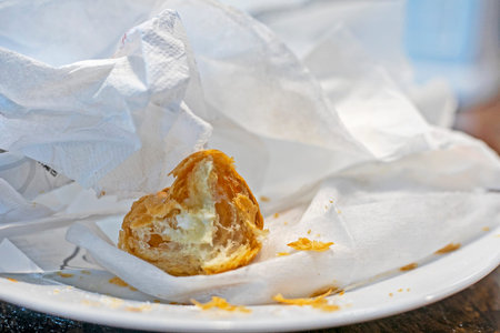 small bitten piece of fresh hot croissant on a napkin. Morning snack. Back to school