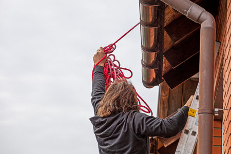 worker climbs a ladder to the roof before installingの写真素材