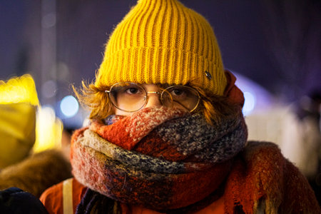 teenage girl in a hat on the background of a Christmas cityの写真素材
