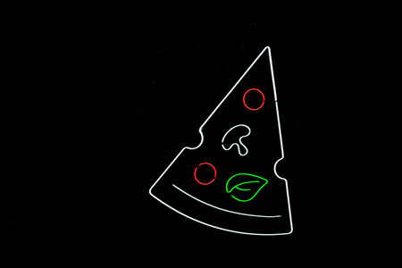 vegetarian pizza slice with fluorescent outline on dark backgroundの写真素材