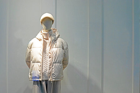 stylish female mannequin in a hat and a light jacket on a gray backgroundの写真素材