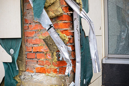 bare brick wall with torn insulation. Repair construction robots