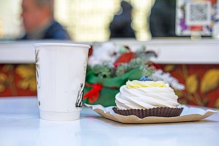 delicious meringue cake with blueberries on a paper plate with a glass of coffee or cocoaの写真素材