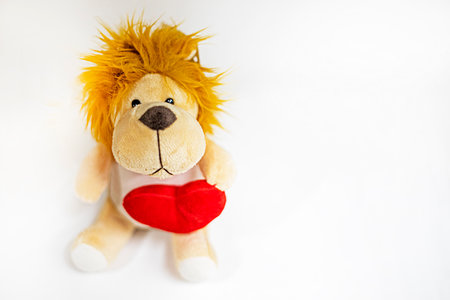 cute toy lion cub with red heart on light backgroundの写真素材