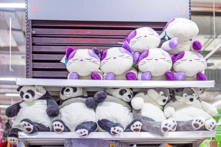 cute soft toy cats and pandas on a shelf in a supermarketの写真素材