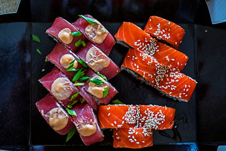 sushi rolls with pieces of tuna and salmon in open packagingの写真素材