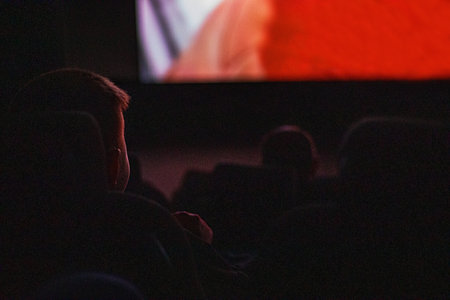 boy watching a movie with the whole family at the cinema. family day out