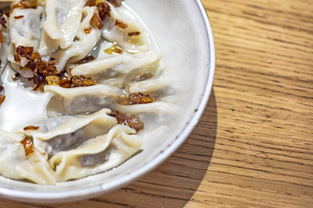 eating dumplings with meat and fried onions with a fork, a national traditional dish of Ukraineの写真素材