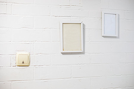 empty picture frames on a stylish brick wall in the interior. mockupの写真素材