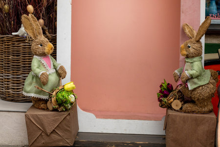 Easter bunny figurines on a pink background outside. Easter holiday