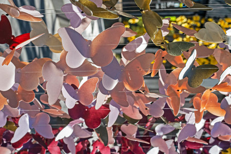 decorative multi-colored garlands with butterflies on a fishing line sway in the wind outsideの写真素材