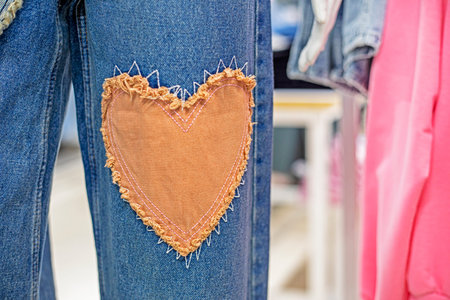 stylish jeans close-up with a patch in the form of a heart. Fashion and style