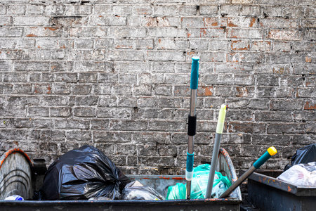 trash cans with garbage and full garbage bags against the background of an old brick wall. environmentの写真素材